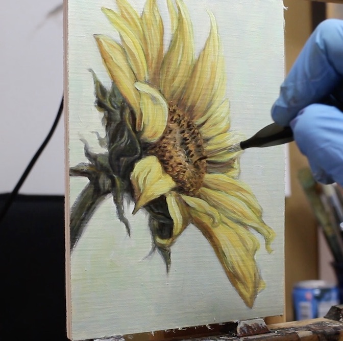 Painting details on the disc florets of sunflower painting.